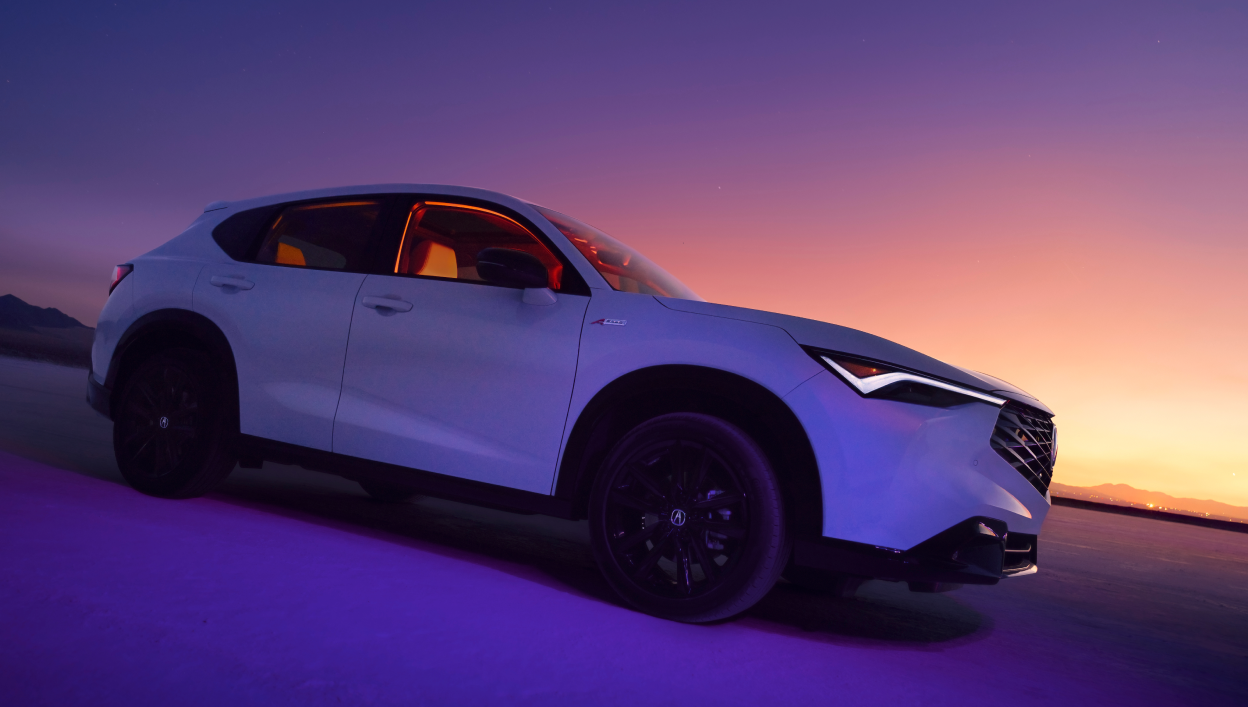 A stationary 2025 Acura ADX with purple and pink hues in the sky.