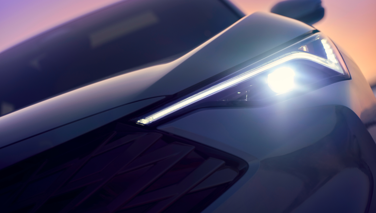 A zoomed-in image of the 2025 Acura ADX with its headlights on.
