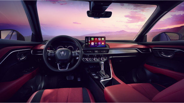 An interior shot of the 2025 Acura ADX revealing the steering wheel, the dashborad and a mountainous view with pink hues in the sky. 