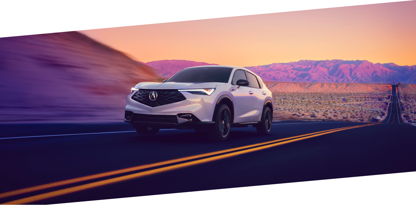 Wide shot of a grey Acura ADX on a mountain road. 