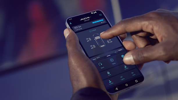 Close up a hand using a cellular device to access Acuralink connected services. 