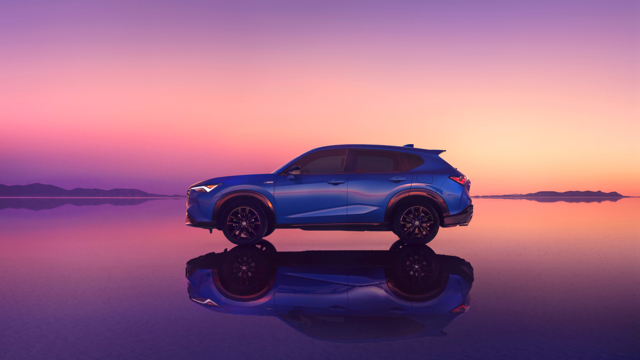 Side-view of an Acura ADX with pink sunset in the background. 