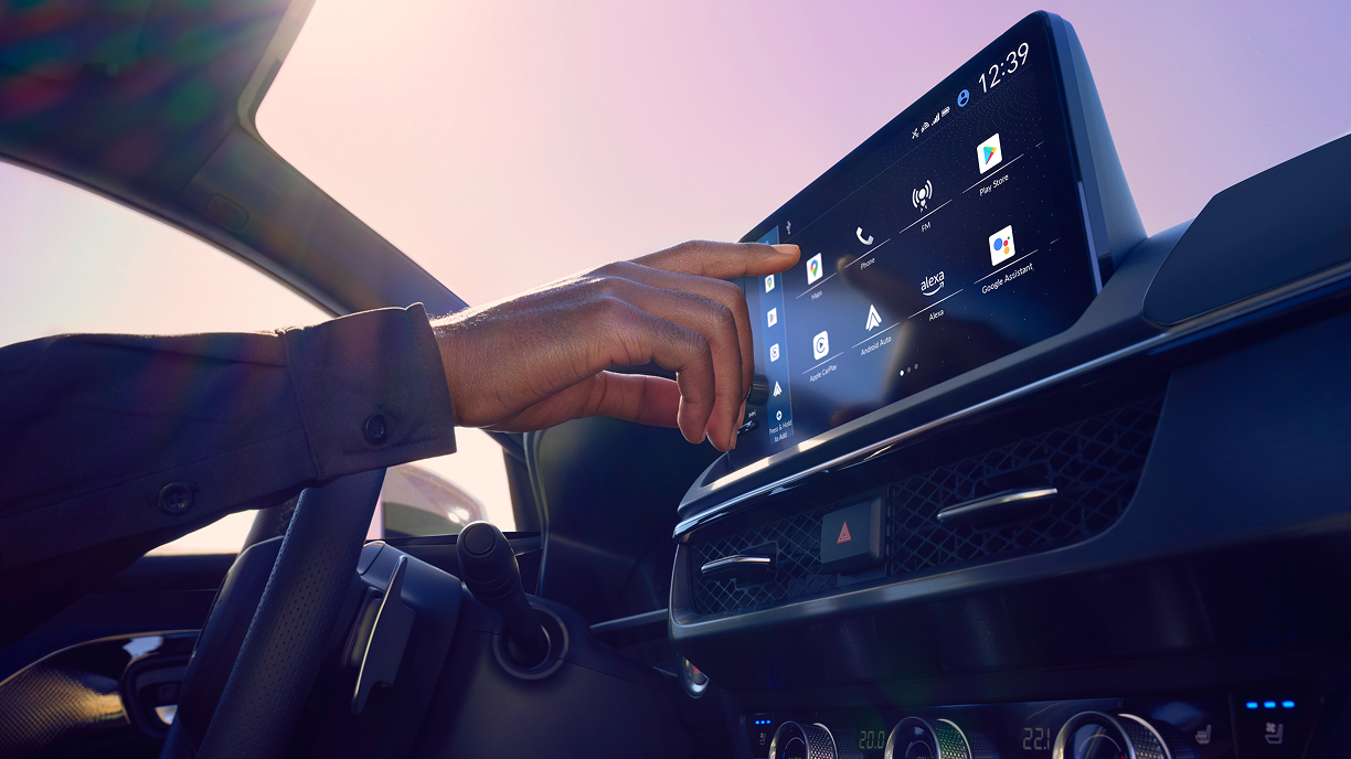 Close-up of driver using Google-built in on the dashboard display. 