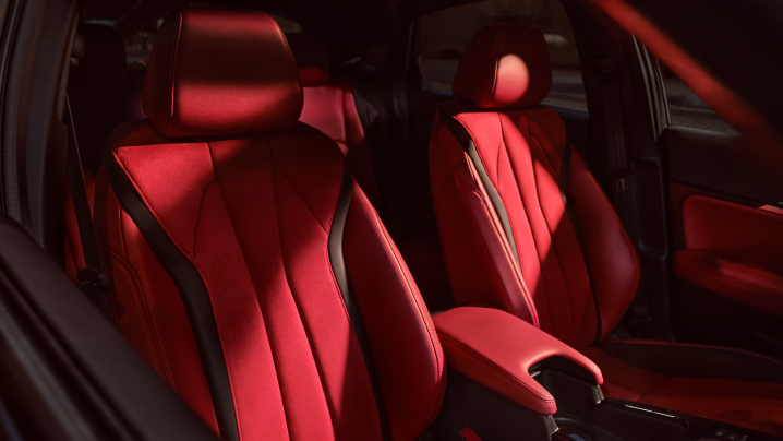Interior closeup of red microsuede-trimmed power front seats in an Integra.