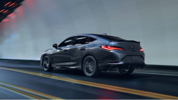 3/4 side rear view of grey Integra travelling in tunnel at night with rear LED lights on.