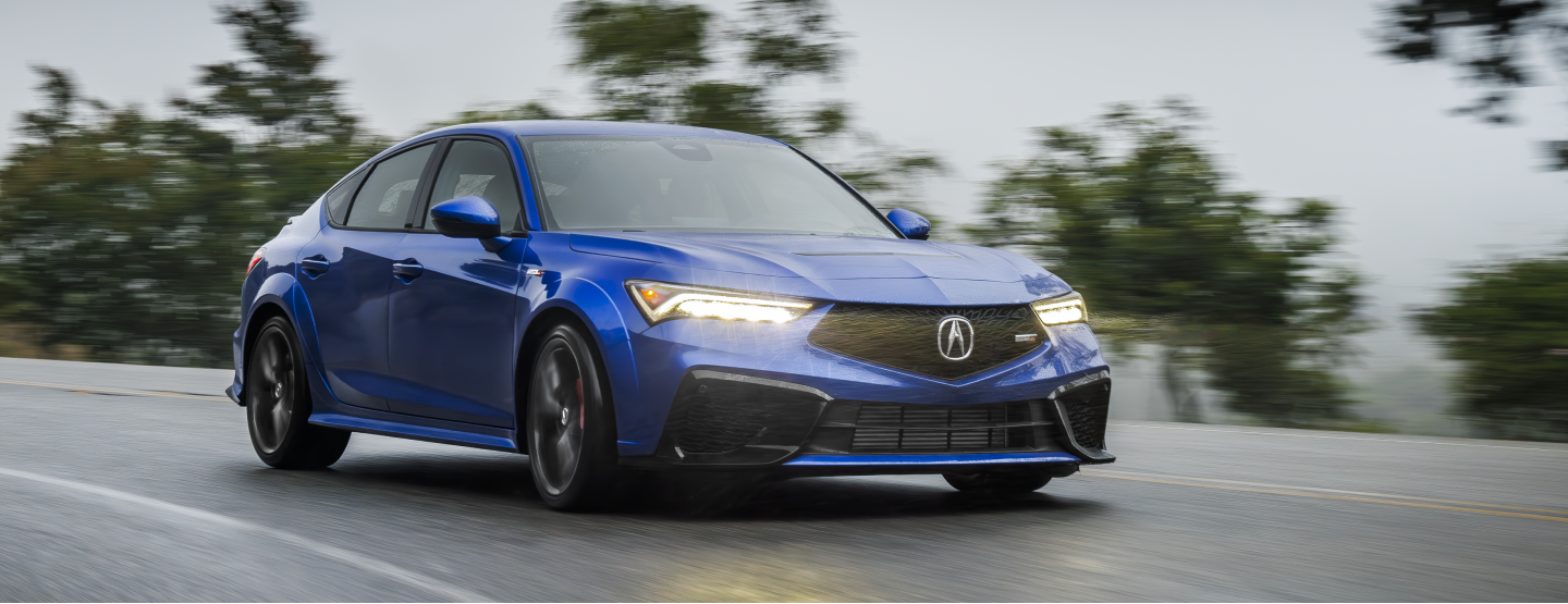 Medium-wide shot of blue Integra taveling on a highway. 