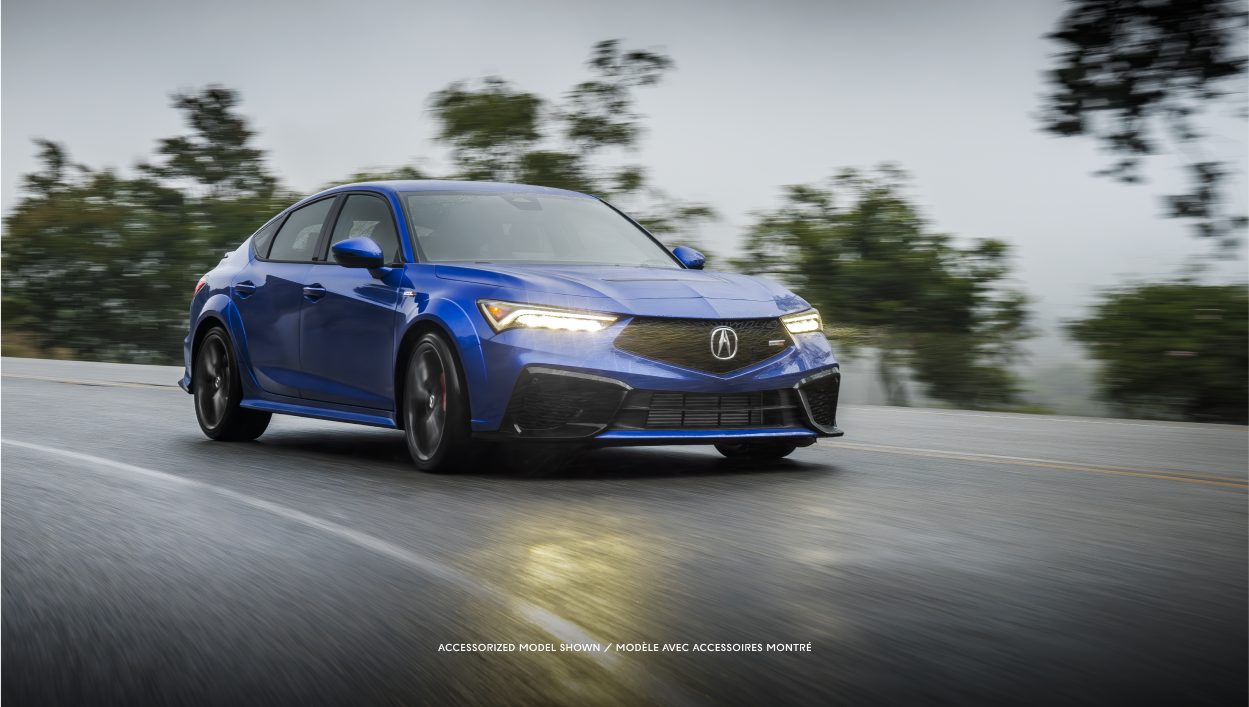 Medium-wide shot of blue Integra taveling on a highway. 