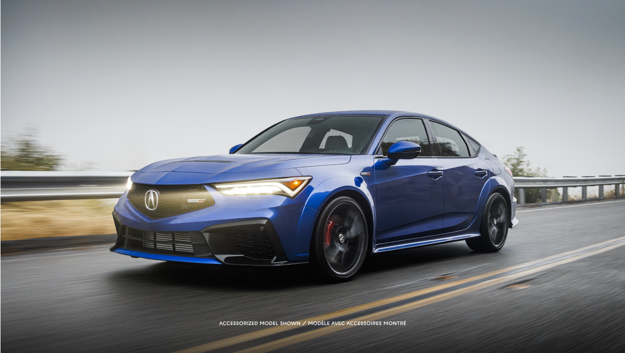 Side-view of a blue Integra driving on a highway. 