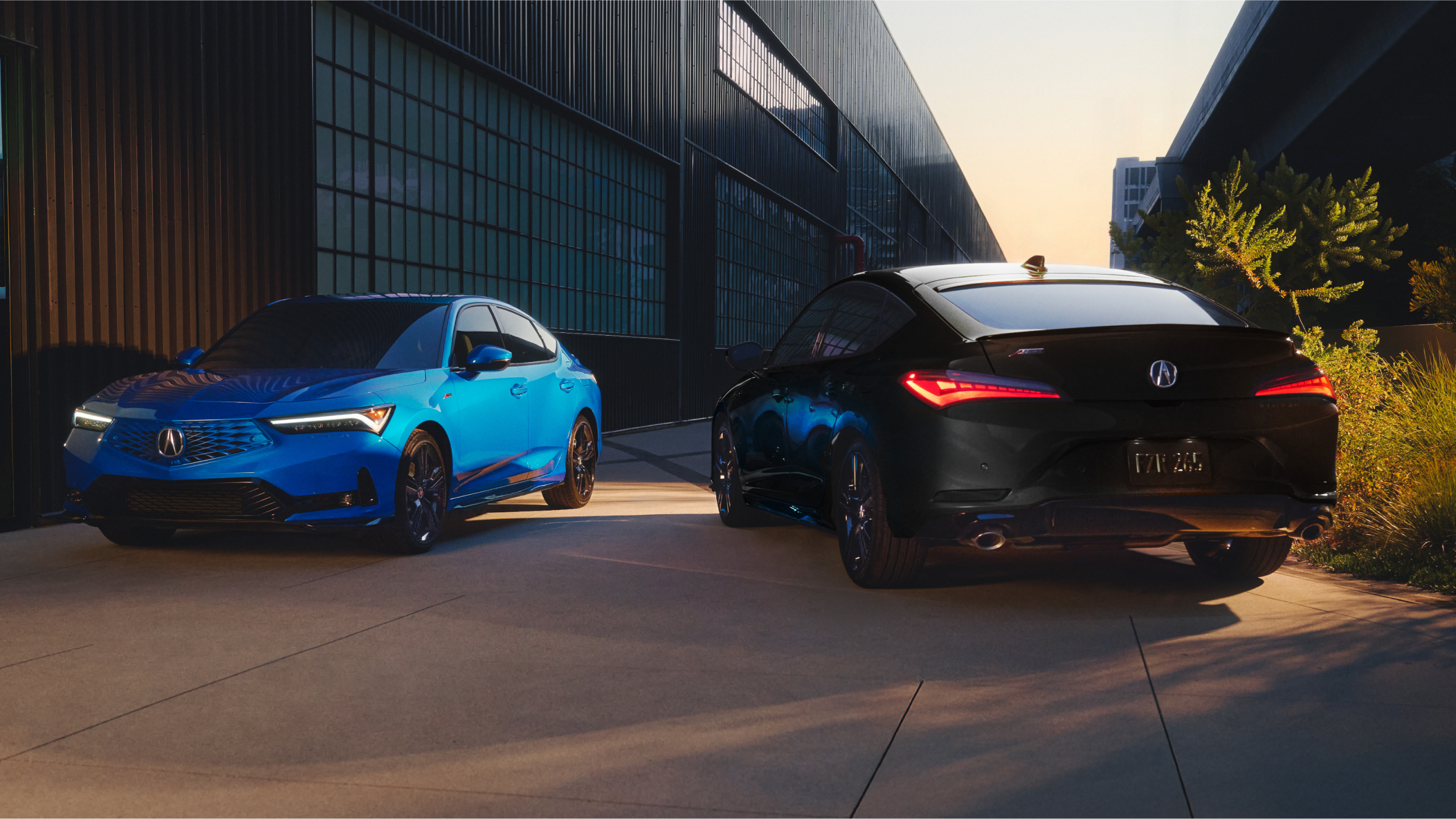 Rear of 2023 Integra, lights on, rear spoiler and dual exhaust