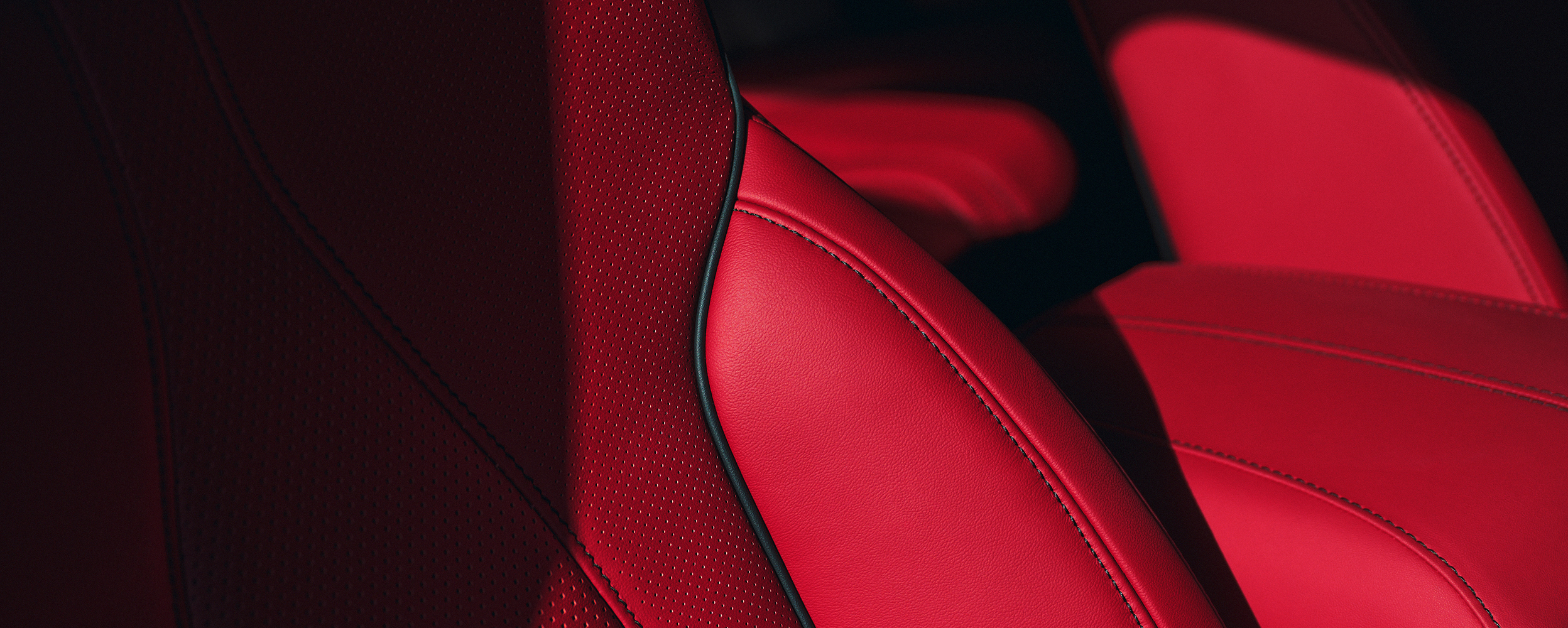 Closeup of red leather seats with Ultrasuede inserts.