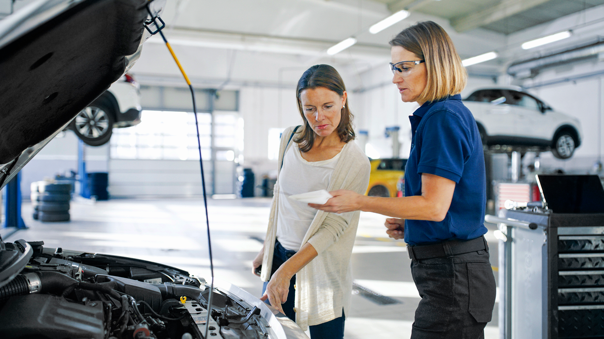 A Acura specialist performs a battery check with a customer. 