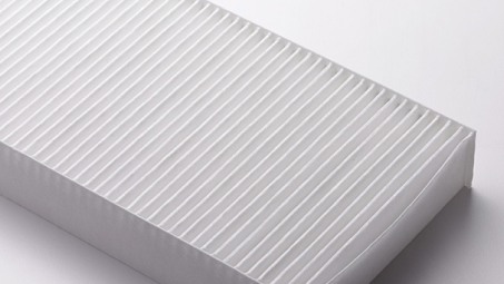 Zoomed in studio shot of an exposed cabin air filter. // Zoom en studio sur un filtre à air d'habitacle exposé